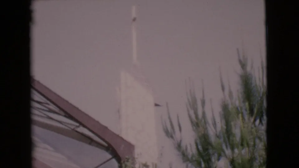 A soft 8mm view of a white steeple and sloped roof in San Diego County, partly blocked by dark window framing.