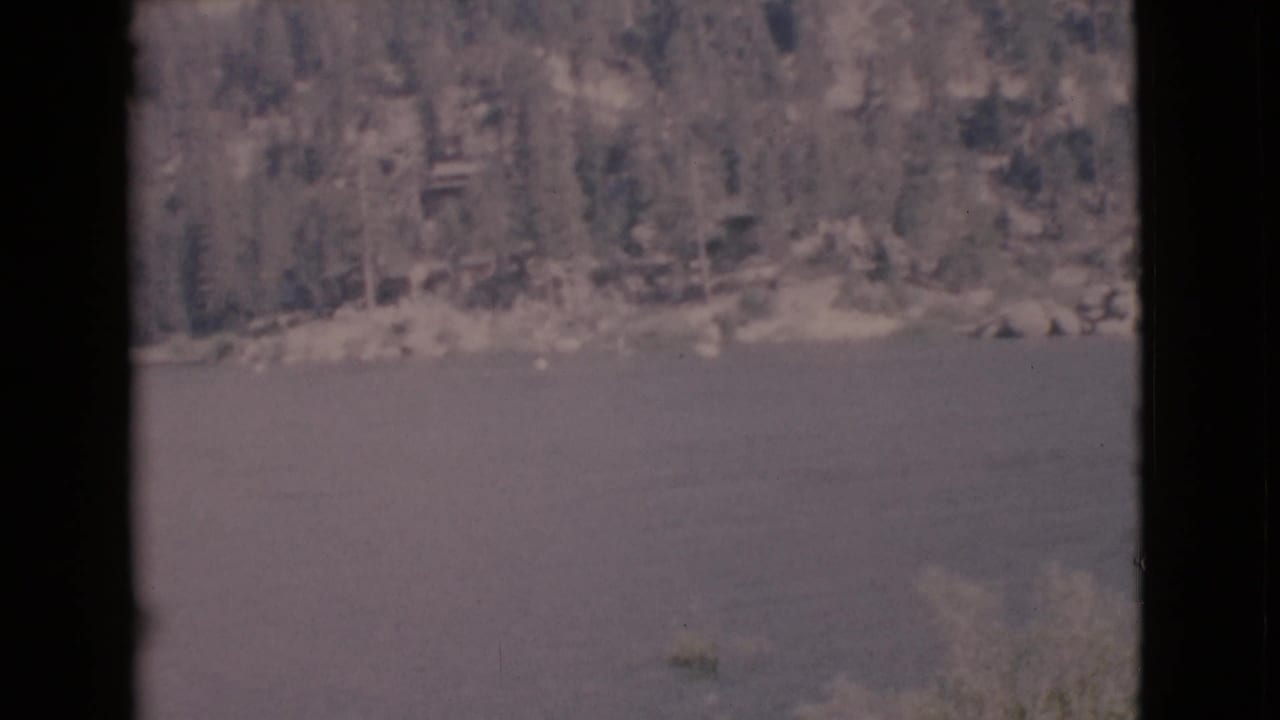 Lake surface with wooded bank and dark window-like borders.