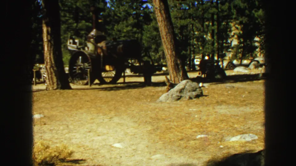 A vintage steam vehicle or tractor appears among trees and rocks, likely part of an outdoor exhibit in the Vancouver footage.