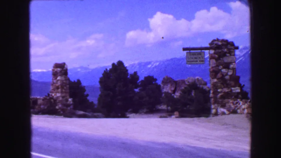 Visitor-shot view of a stone Geiger Lookout sign at a mountain roadside overlook, supported by the clip metadata as 1968 travel footage.