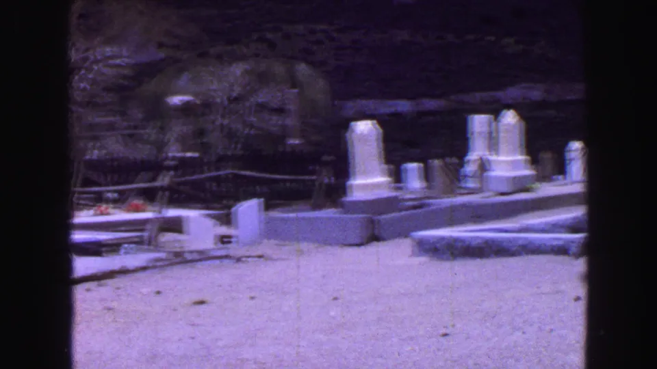 End of the 1968 Vancouver cemetery pan, with several pale headstones, flat grave slabs, bare trees, and open ground.