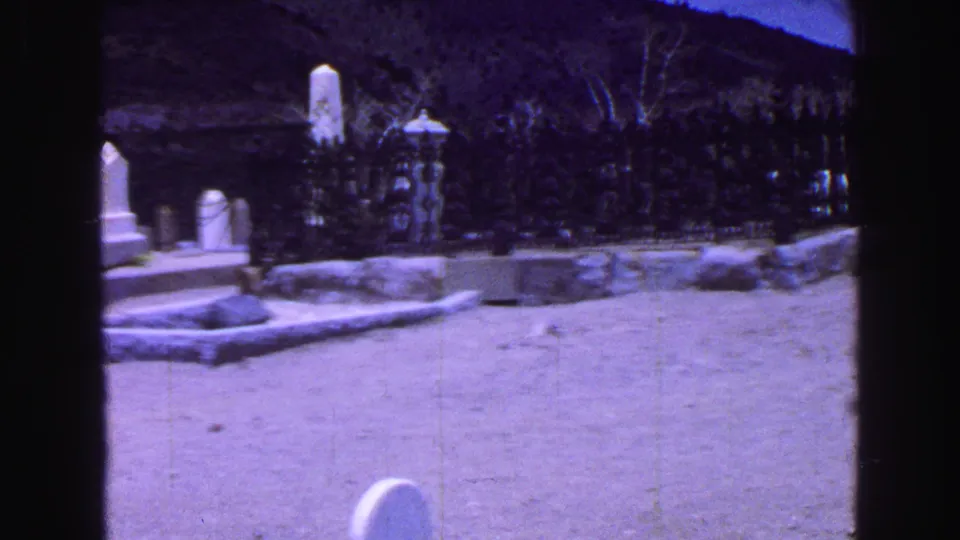 The 1968 Vancouver cemetery view continues across pale ground, white markers, low grave edging, and dark fencing.