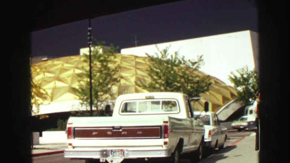 1968 Vancouver street view with a white Ford pickup, nearby cars, trees, and a distinctive gold dome structure in the background.