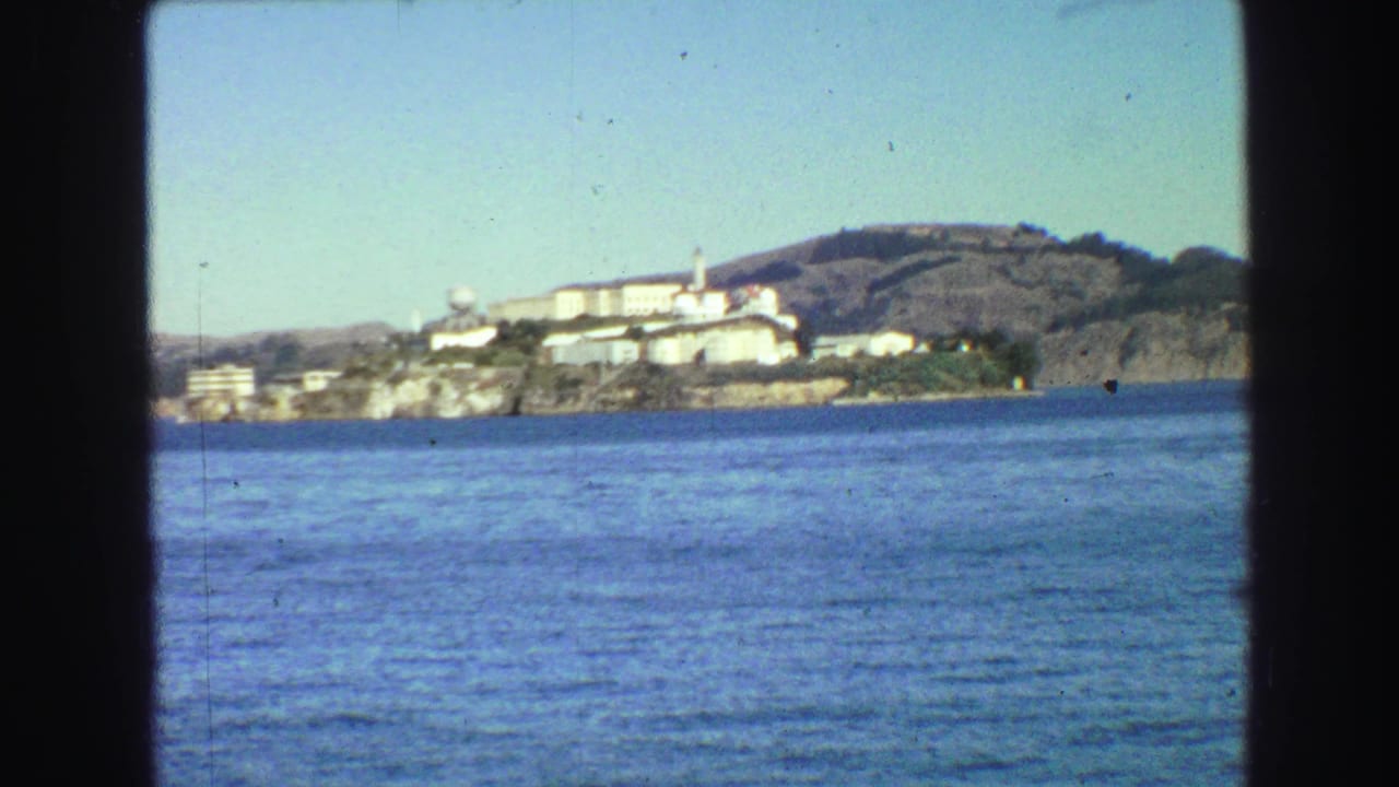 Alcatraz Island across blue bay water under a clear sky.