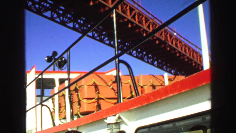 1968 Vancouver deck view showing orange life rafts, red railing, and a steel truss bridge overhead.