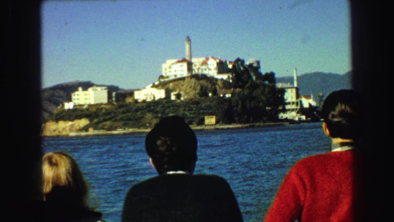 Passengers face the water as Alcatraz Island fills the background.