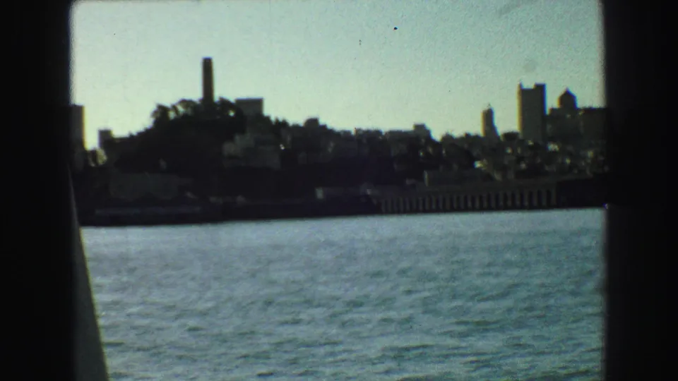 1968 Vancouver skyline viewed from the water, with silhouetted boat supports crossing the frame.