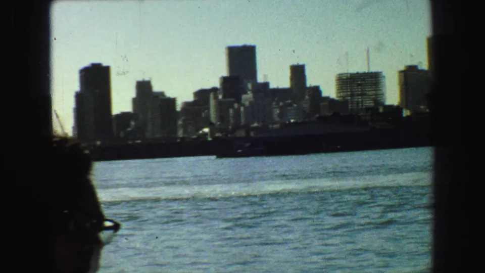 1968 Vancouver downtown towers across the harbor, with a partial silhouetted passenger at the frame edge.