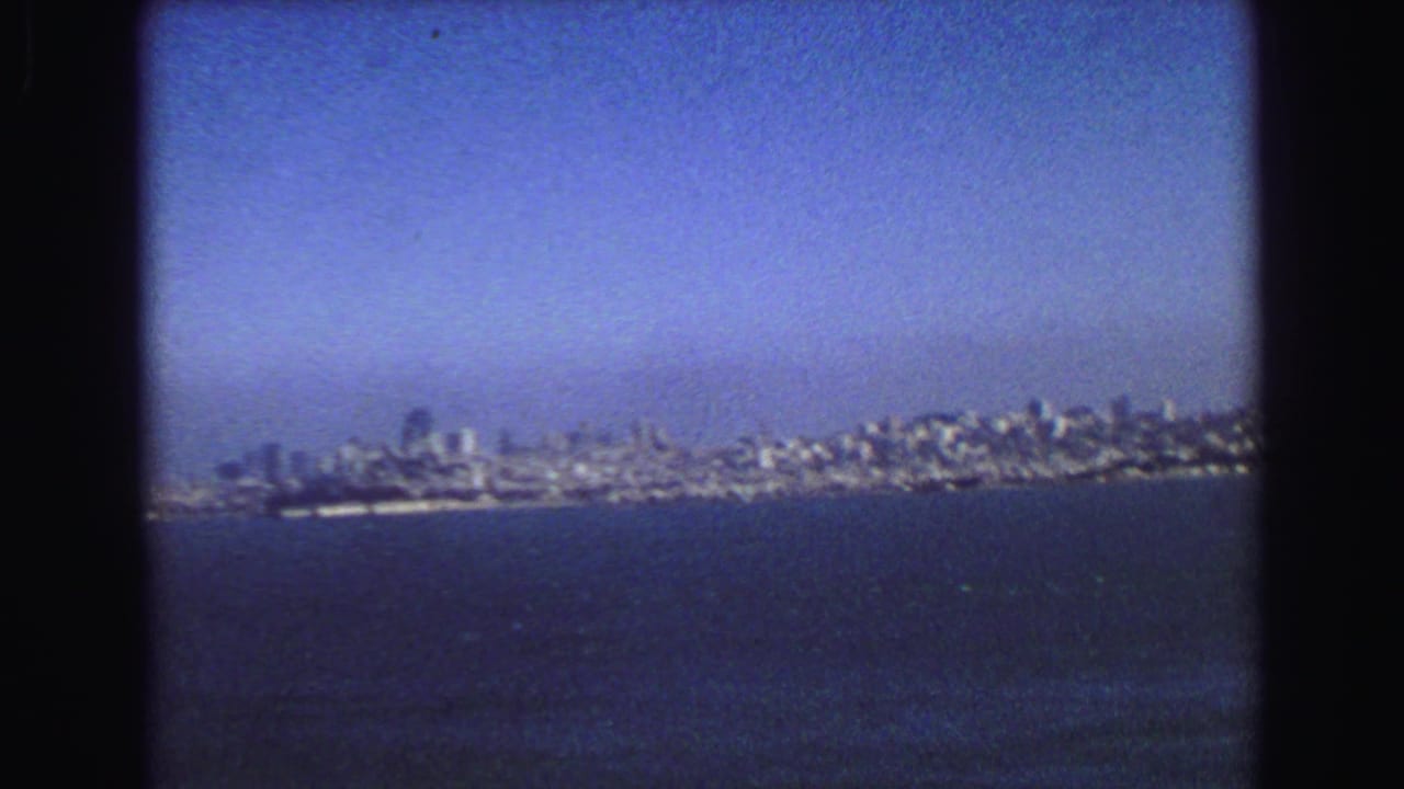 City skyline stretches along the shoreline beyond open water.