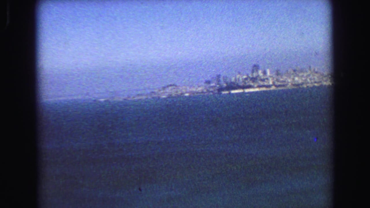 End of the 1968 Vancouver pan, with the waterfront skyline small on the horizon above dark blue water.