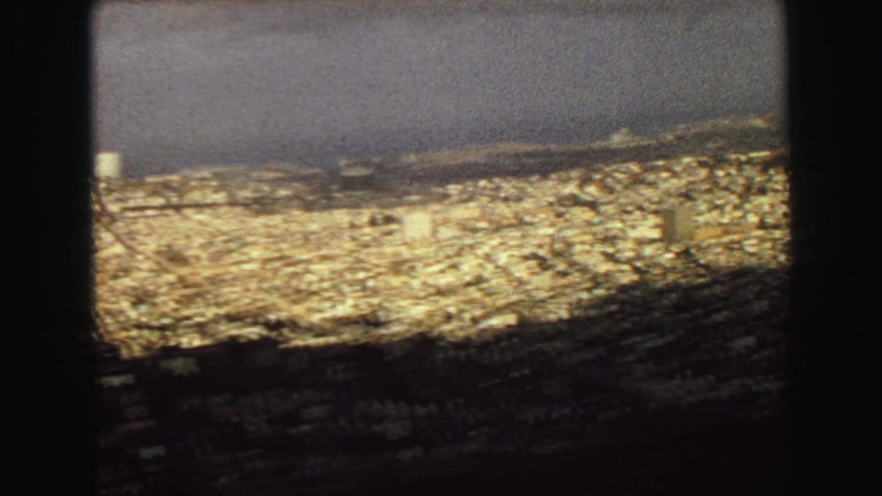 Late-1960s Vancouver city view from above, with tightly packed buildings leading toward the waterfront.