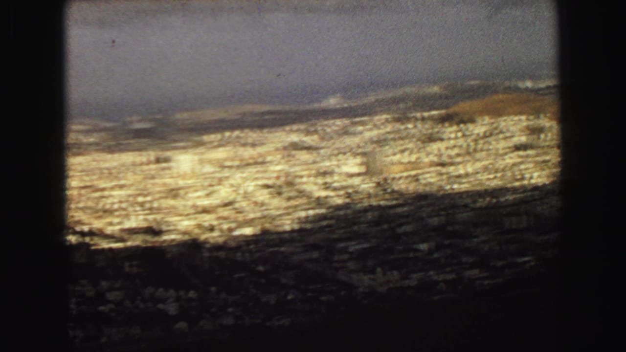 Elevated view across a dense coastal city with dark window-like framing.