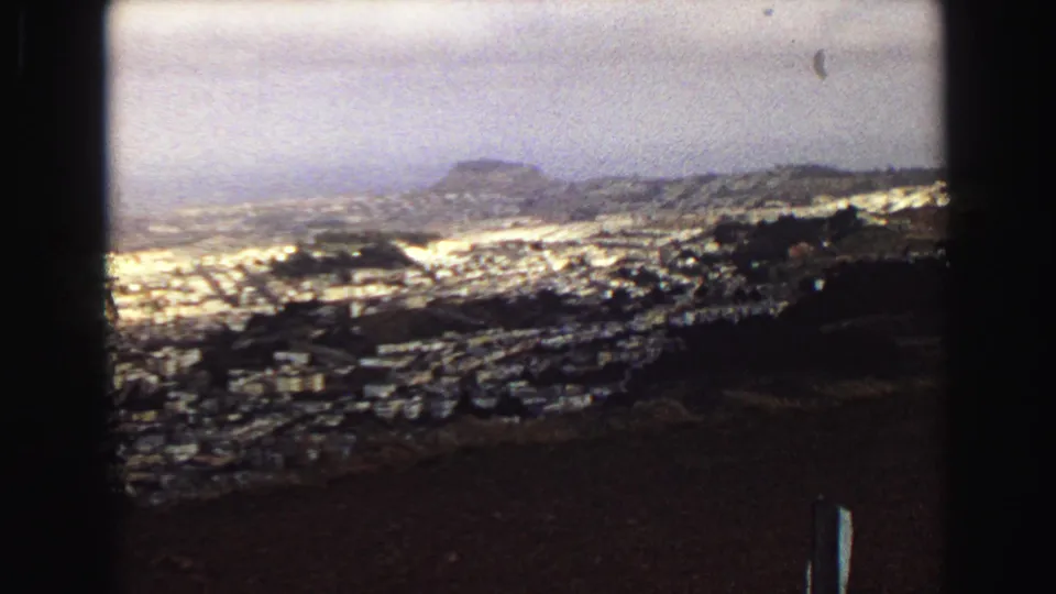 Final 1968 Vancouver frame showing a broad coastal city view with rooftops, hills, and heavy dark foreground framing.