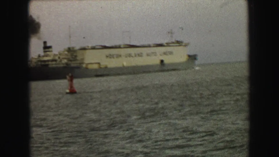 1968 Vancouver harbor view of a tan ocean liner moving across choppy water with a red buoy under a gray sky.