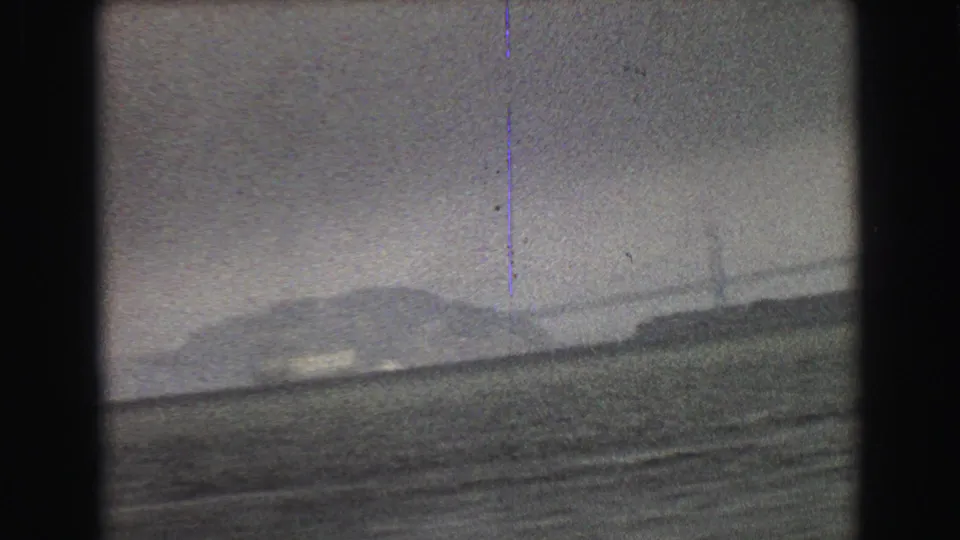 1968 8mm frame showing open water and a faint distant vessel, with soft focus and visible film grain.