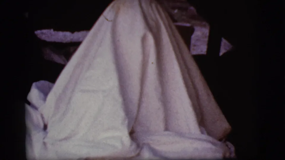 The white sheet hangs in a tall ghost-like form during a 1968 Cottonwood, Arizona home-movie moment.