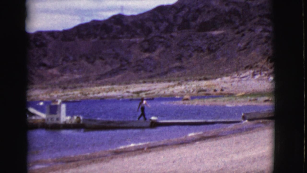 Person moving briskly along a narrow dock near shore.