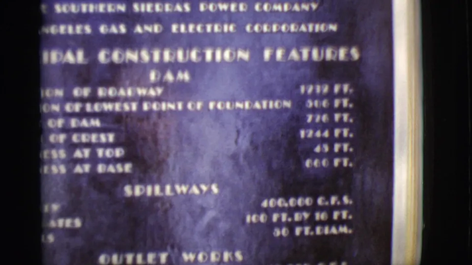 1968 Arizona 8mm frame showing the upper portion of a dam construction features board with white technical lettering.