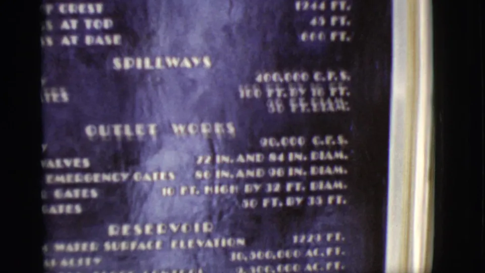 1968 Arizona 8mm frame with a close view of the dam specifications board, including spillways and reservoir headings.