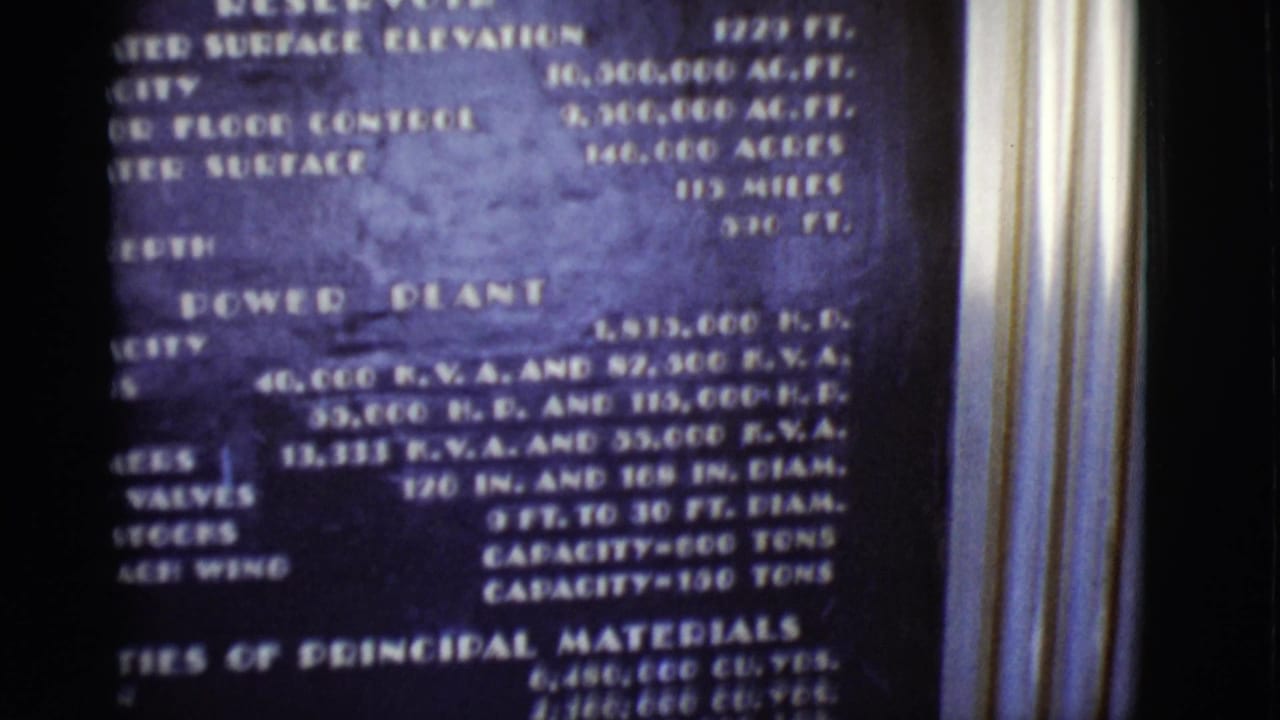1968 Arizona home-movie frame showing a power plant information plaque with technical specifications in soft focus.