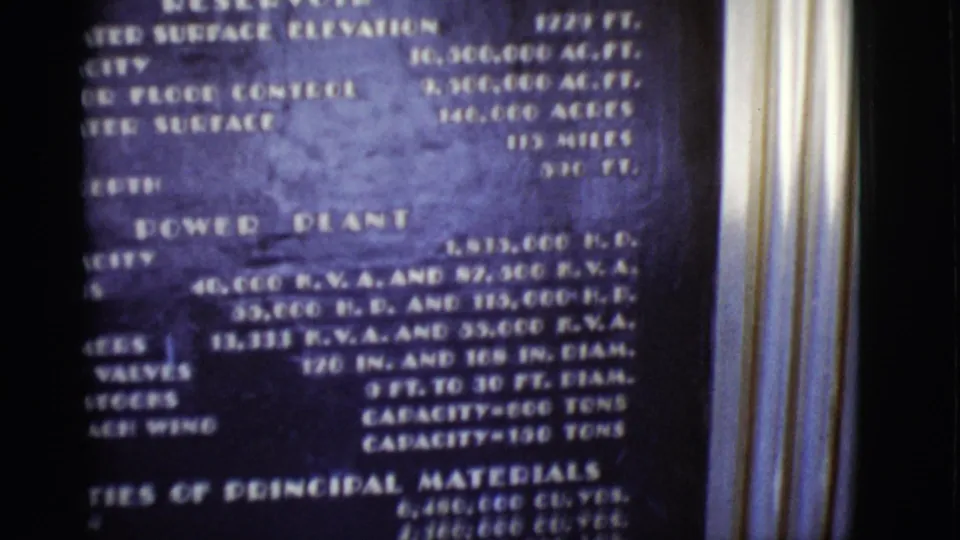 1968 Arizona home-movie frame showing a power plant information plaque with technical specifications in soft focus.