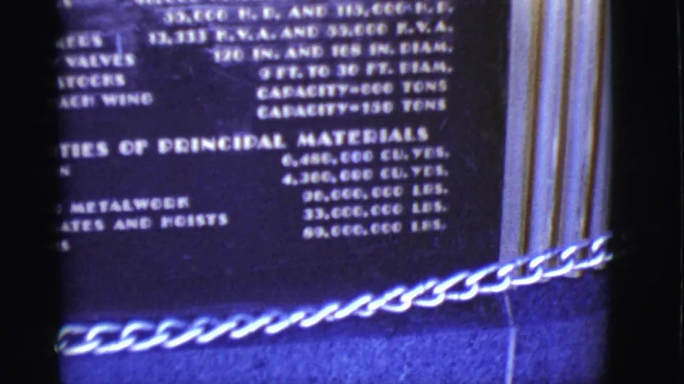 Lower section of the Arizona power plant plaque, with a chain barrier visible across the foreground.