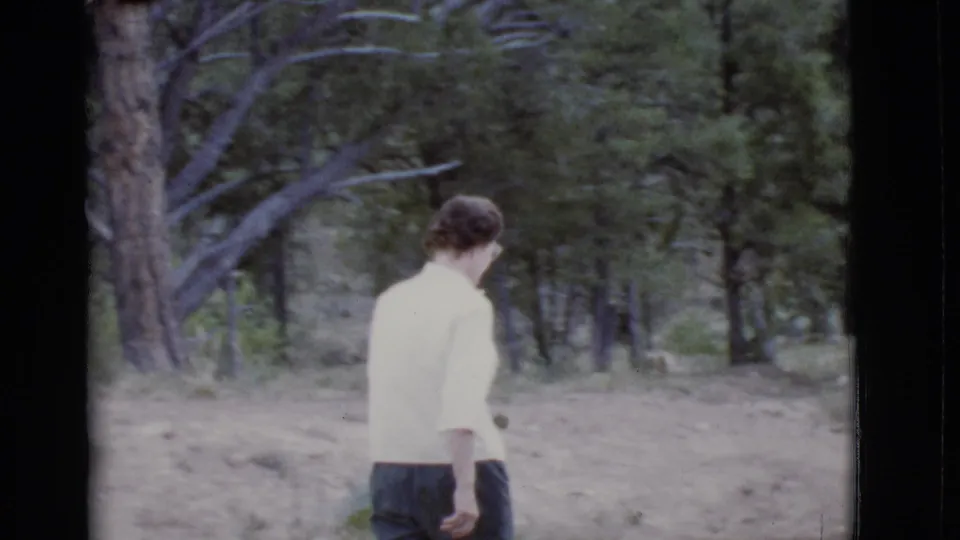 The woman walks away from the camera along a dirt path, framed by trees in the supplied 1968 Arizona park context.