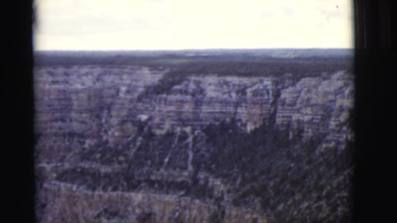 High view across rocky canyon formations with a hazy horizon.