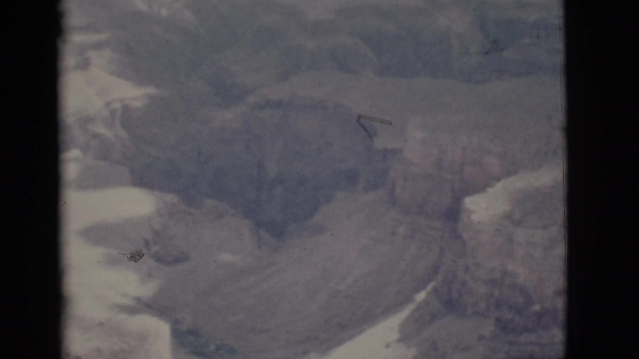 Soft canyon view with layered rock walls and dark film borders.