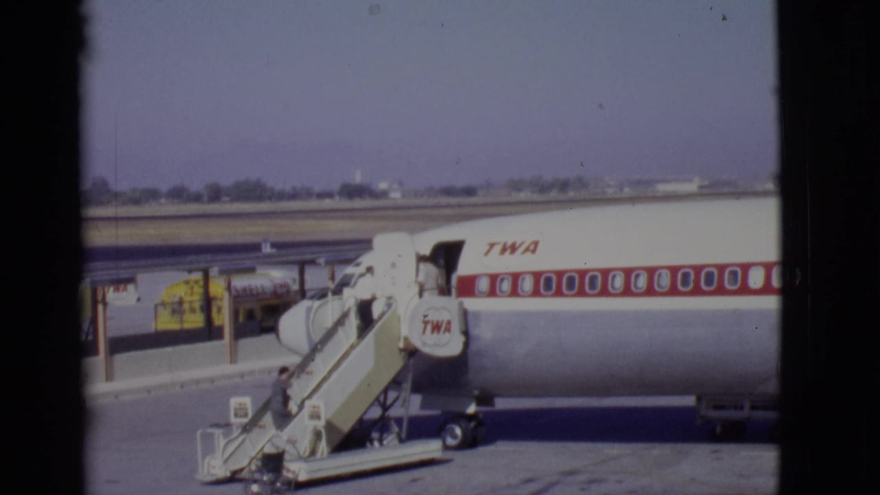 A passenger climbs the stairs toward the open door of a TWA airliner at an Arizona airport in 1968.