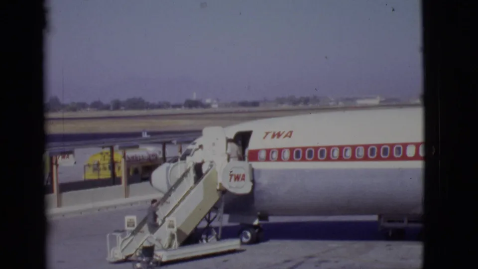 A passenger climbs the stairs toward the open door of a TWA airliner at an Arizona airport in 1968.