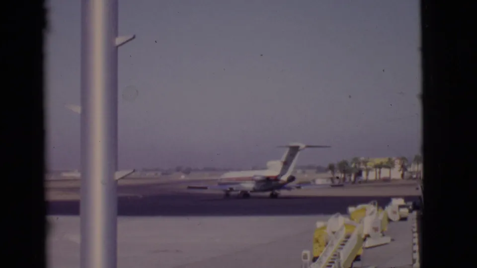 The final frame shows the TWA jet farther away on the Arizona airport tarmac, with yellow service gear and palm trees visible.