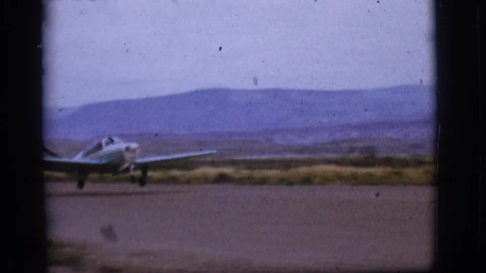 Closer 8mm view of the small plane on the runway during the 1968 Flagstaff takeoff sequence.