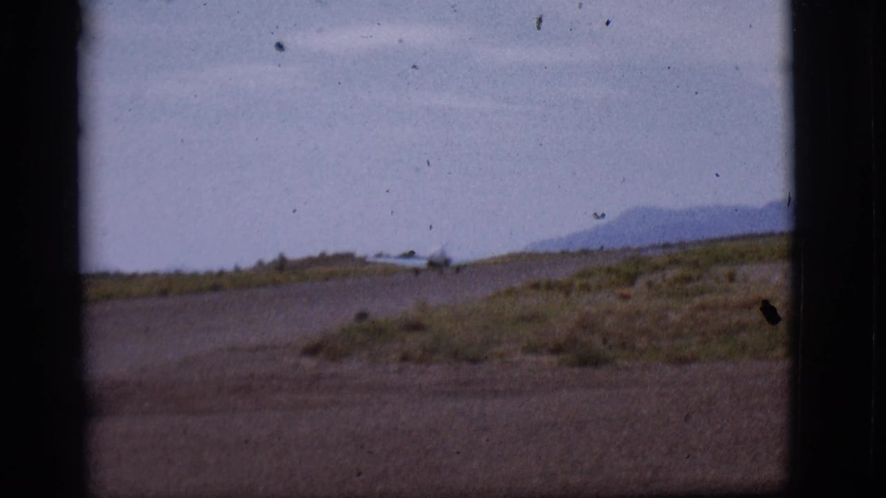 Small single-engine plane appears on a remote Flagstaff runway in 1968 home-movie footage, partly blocked by a dark window or film edge.
