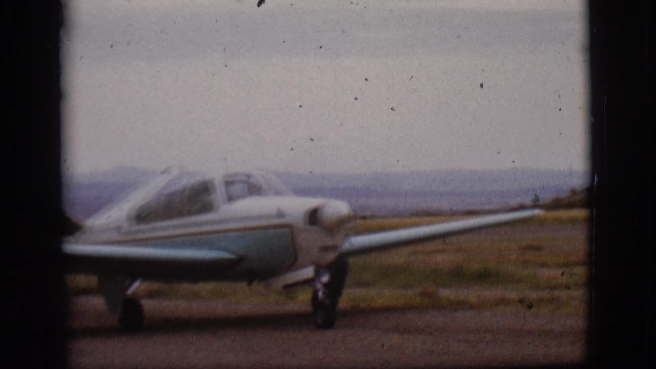 Small light airplane seen closer from the side as it moves along the runway.