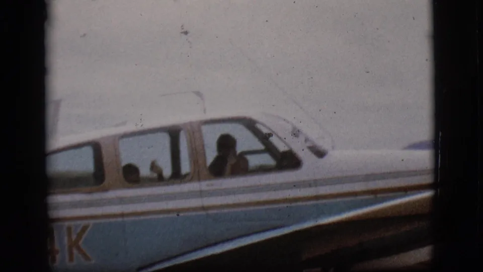 Side windows of the blue and white propeller plane in Flagstaff, Arizona, with passenger silhouettes visible through the cabin glass.