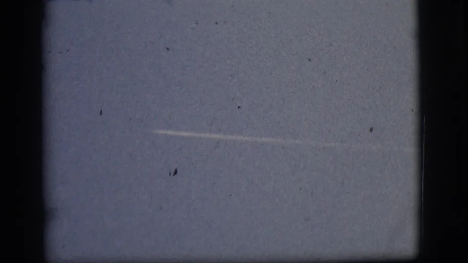 Flagstaff-attributed 1968 8mm sky frame with a pale horizontal streak, soft grain, dust marks, and dark gate borders.