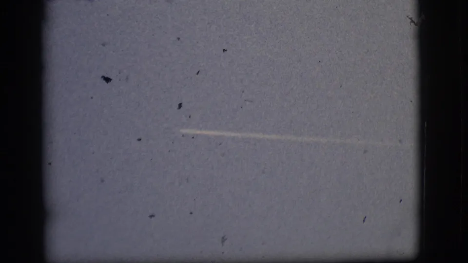 1968 Flagstaff-attributed 8mm frame showing a brighter horizontal sky streak with dust, scratches, and dark rounded borders.