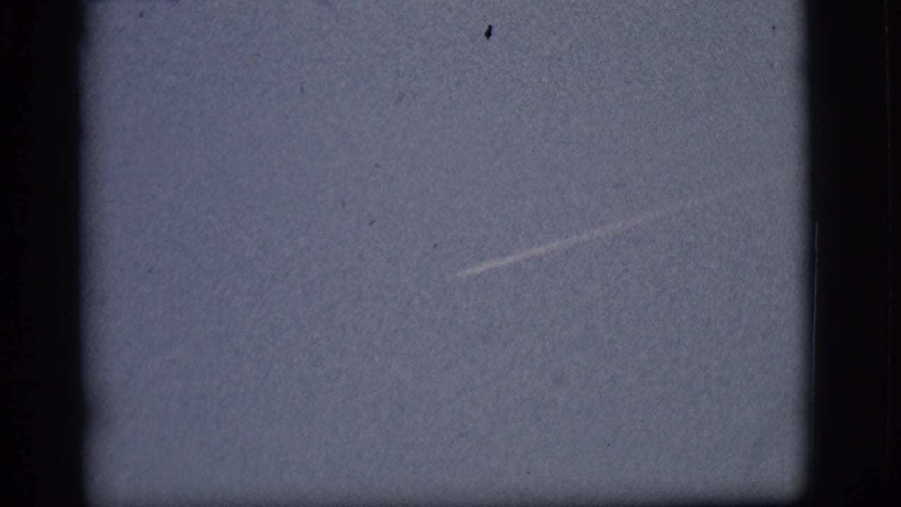 Faint contrail angled across an otherwise empty pale sky.