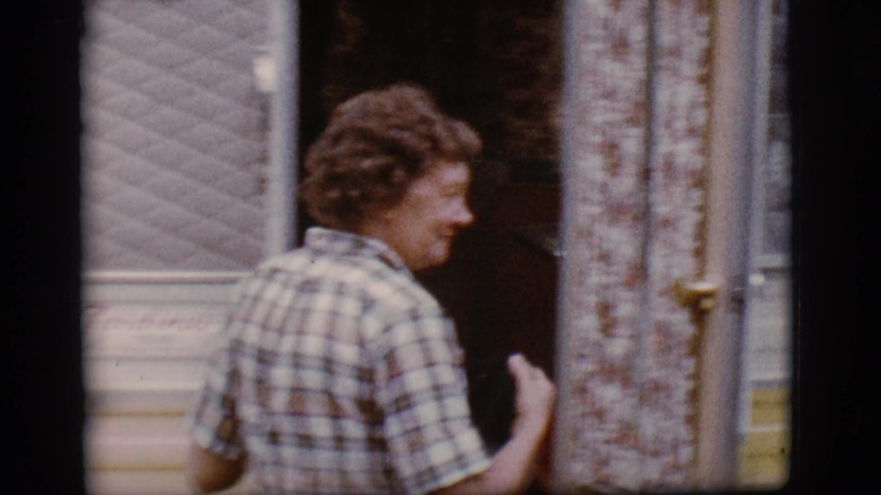 Woman in plaid turns toward the open camper doorway.