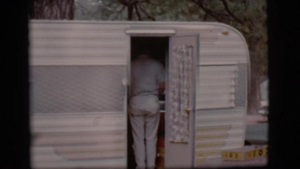 Open door of a 1968 Flagstaff campground camper, with a person in light clothing standing partly inside the trailer.