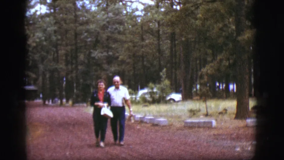 A 1968 home-movie frame shows the elderly couple approaching the camera on a dirt path near Flagstaff.
