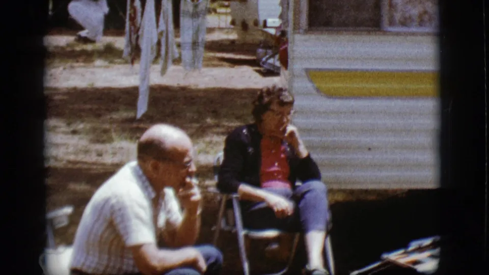 The 1968 Flagstaff footage shows a man in the foreground and a woman seated near the vintage trailer.