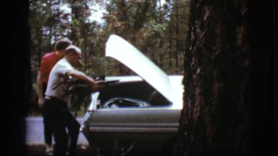 The adults reach a light-colored vintage car with its hood raised during the Flagstaff roadside stop.