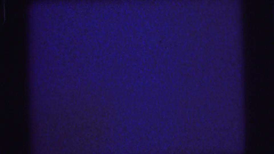 1976 Lynbrook 8mm frame with blue film density, a broad black vertical band, grain, and minor scratches.
