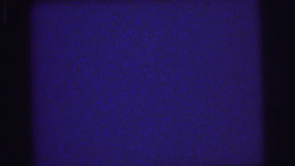 1976 Lynbrook 8mm frame showing blue grain, dark vertical border areas, and a faint horizontal line across the frame.