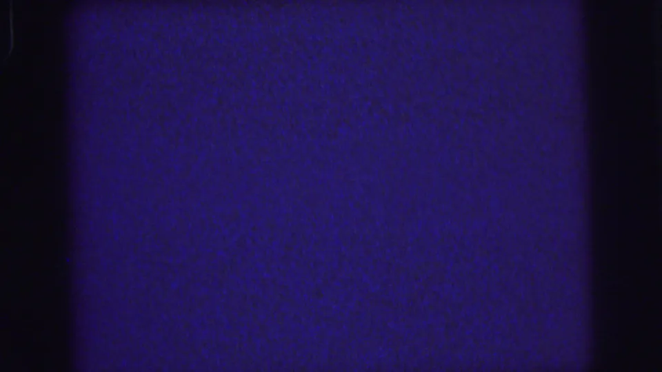 1976 Lynbrook 8mm home-movie frame showing a dark blue textured field with grain, edge shadowing, and slight flicker.