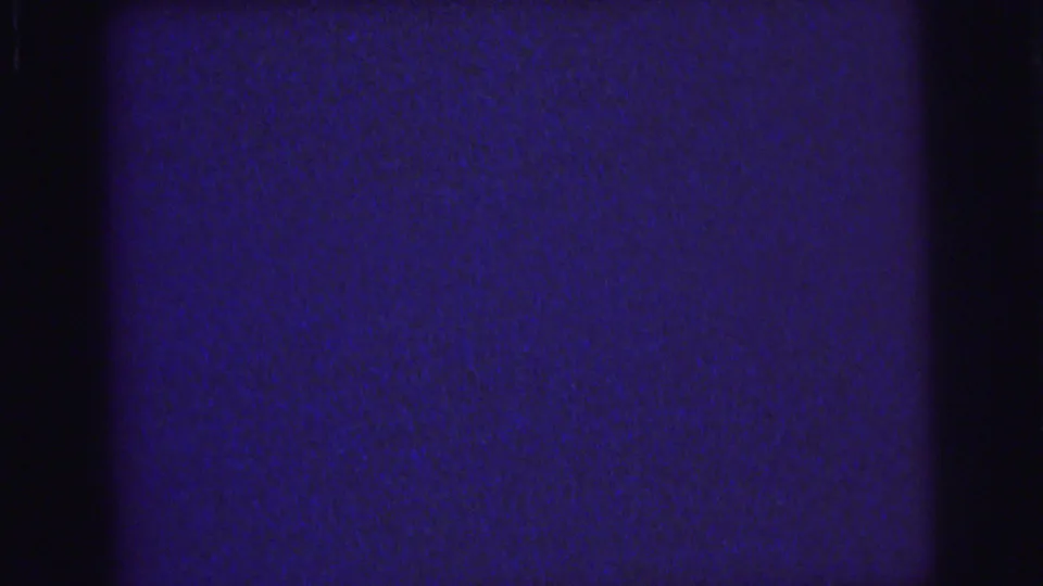 1976 Lynbrook 8mm frame with deep blue grain, dark vertical bands, and subtle surface wear from the scanned film.