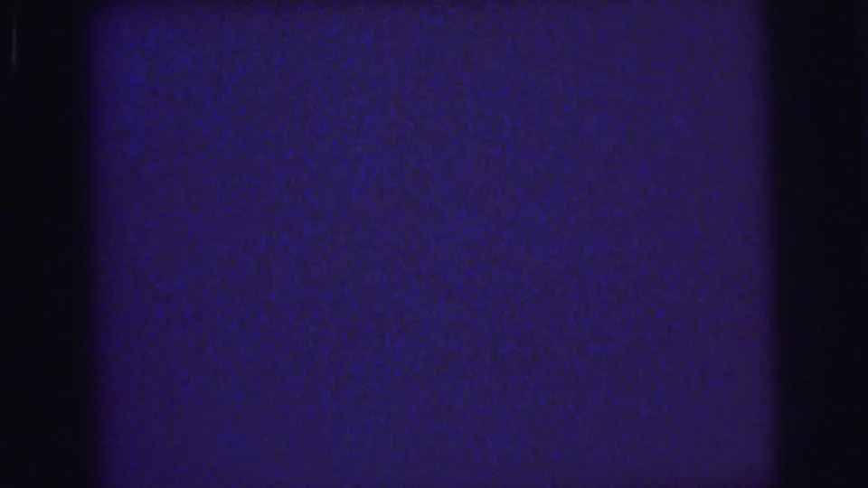1976 Lynbrook 8mm home-movie frame showing a blue static field, visible grain, horizontal seam, and gate-edge darkness.