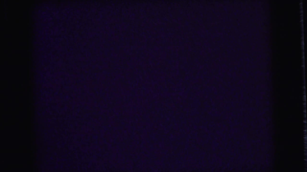 Very dark film frame with little visible detail.